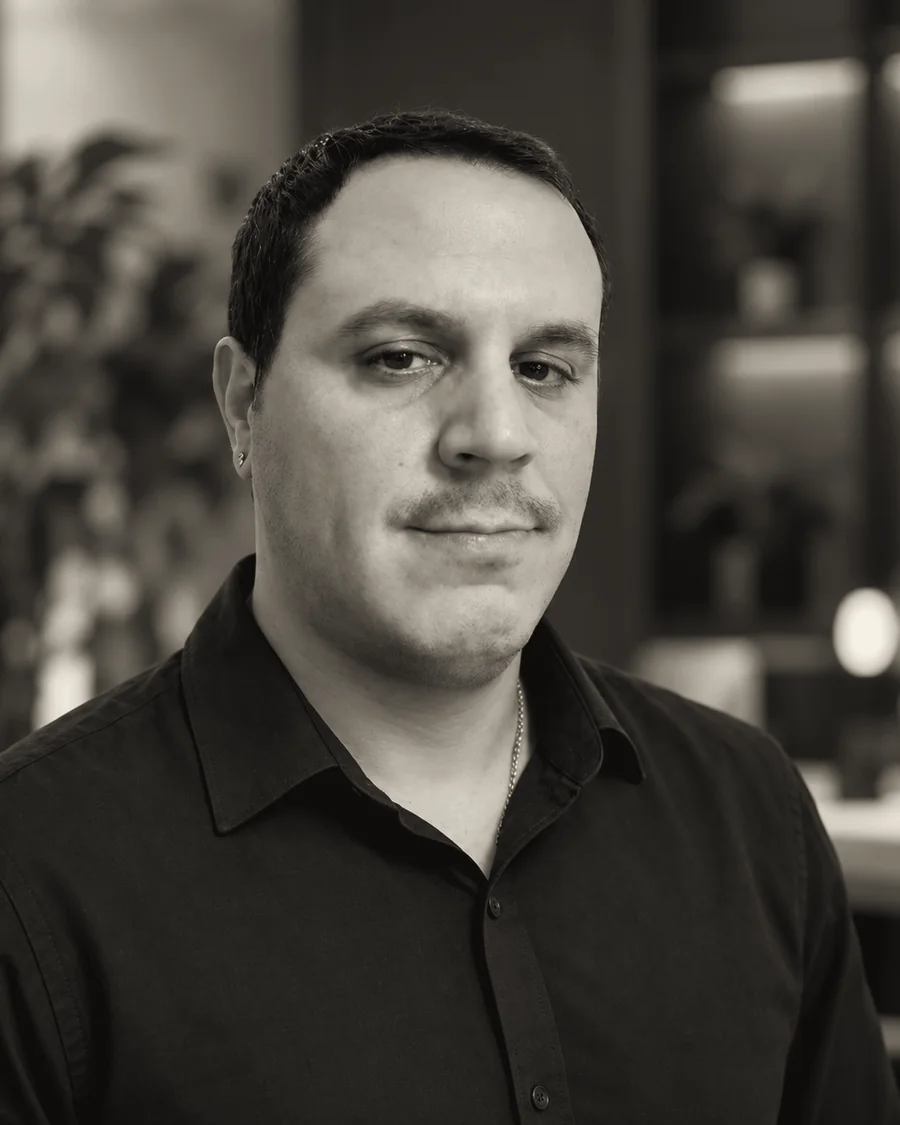 Hezi, partner and full-stack developer at Art-E-Shock, in a black shirt in the studio
